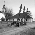 útakadály a falu központjában, háttérben a római katolikus templom.